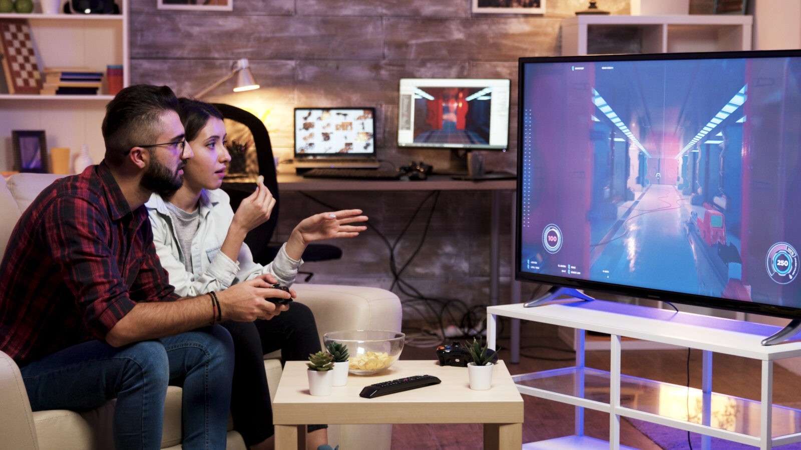 man sitting couch playing video games television with girlfriend him
